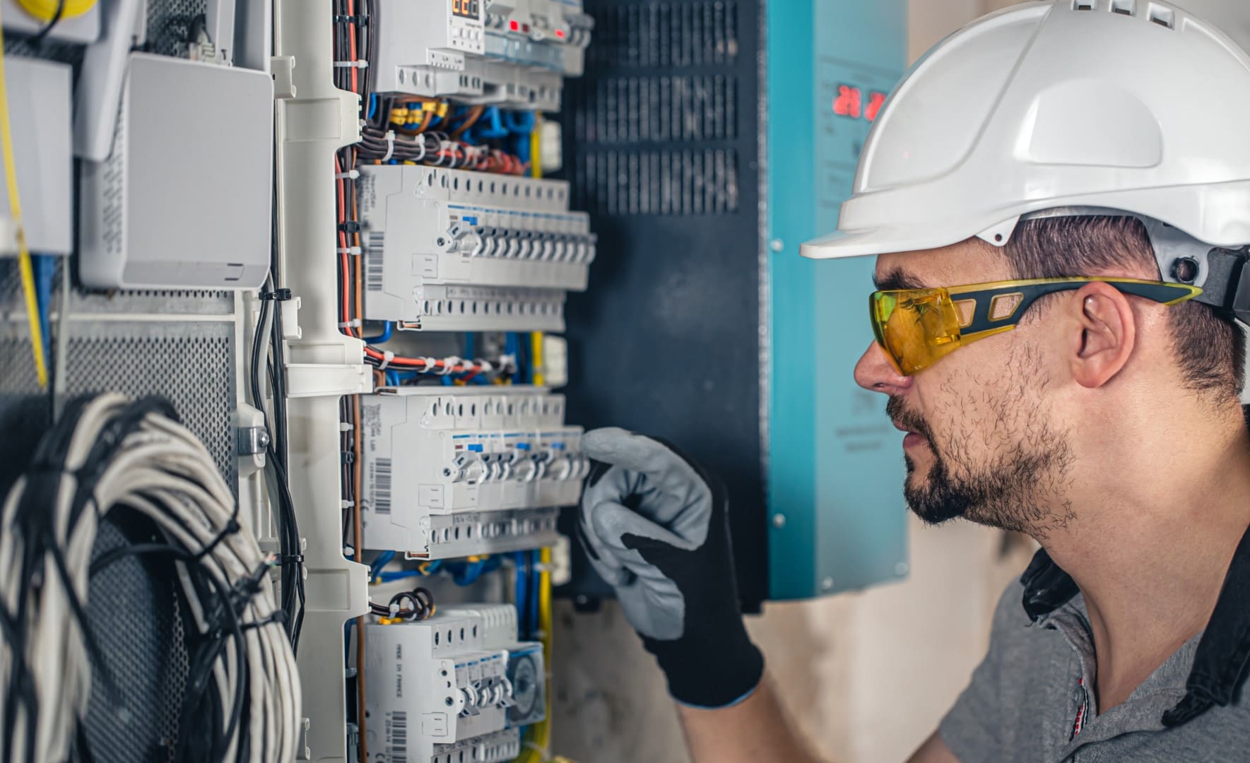 A male technician checking the switchboard.